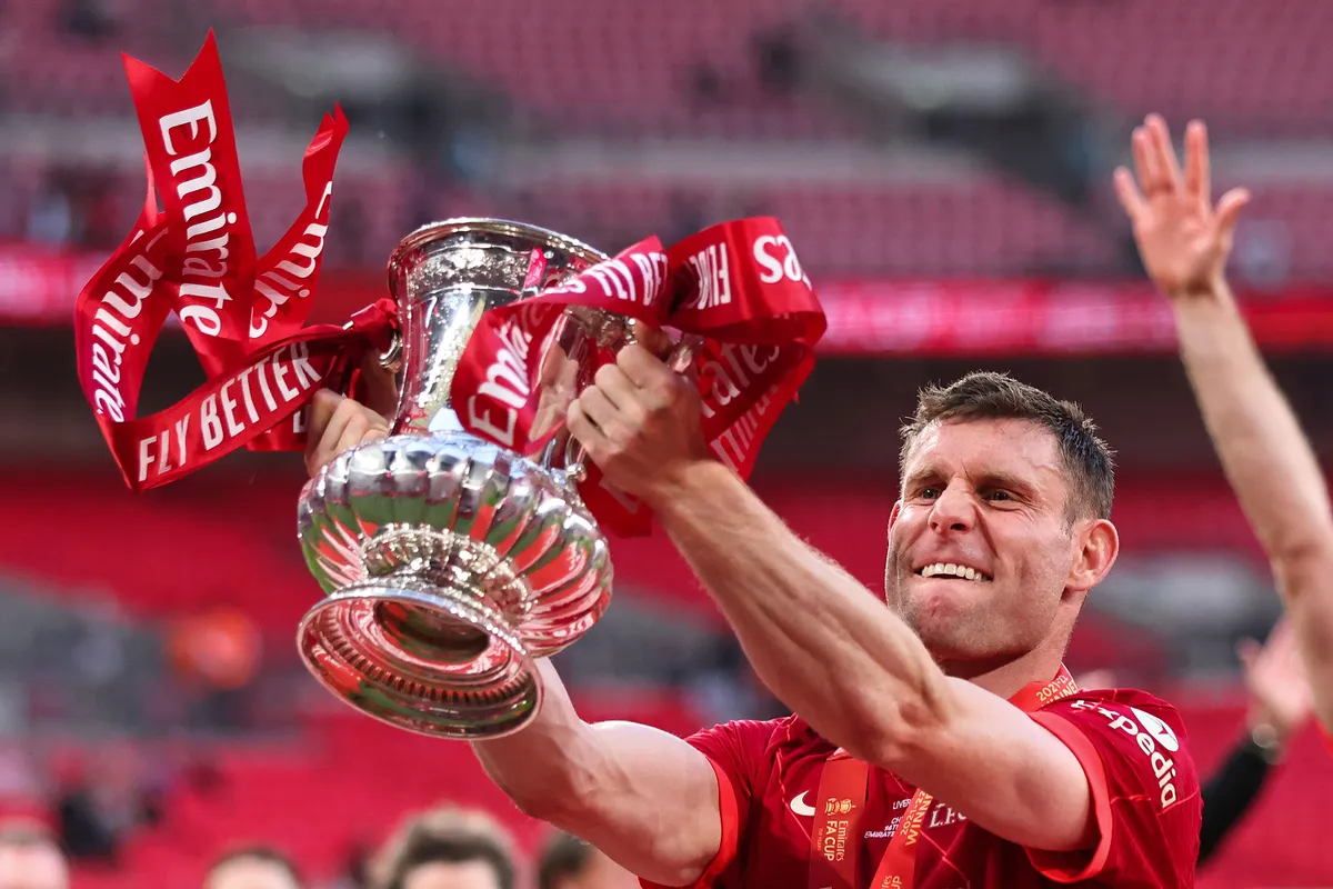 LONDON, ENGLAND - MAY 14: James Milner of Liverpool celebrates with the Emirates FA Cup trophy following his team's victory in The FA Cup Final match between Chelsea and Liverpool at Wembley Stadium on May 14, 2022 in London, England. (Photo by Marc Atkins/Getty Images)