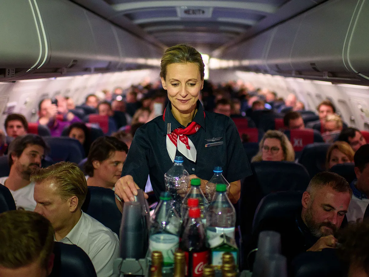 An Air Berlin steward serves drink's on the bankrupt aviation concern's last flight in Munich, Germany, 27 October 2017. The company terminated all services after the last flight from Munich to Berlin's Tegel airport. Photo: Gregor Fischer/dpa (Photo by Gregor Fischer/picture alliance via Getty Images)