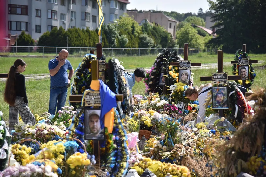 LVIV, UKRAINE - MAY 28: People near the graves of Ukrainian soldiers killed in the Russian-Ukrainian war at Lychakiv Cemetery during Heroes' Day in Lviv, Ukraine on May 28, 2023. Heroes' Day is an annual holiday in Ukraine, established in honor of Ukrainian soldiers - fighters for independent cathedral Ukrainian state. Due to the Russian-Ukrainian war, this year, first of all, the fighters for the independence of Ukraine who were killed in it were honored. People came to the burial of soldiers at the Lychakiv cemetery. Also, in the garrison church of the holy apostles Peter and Paul, they prayed for the heroes killed in this war. The temple also held a "Letter without an answer" campaign - when everyone could write words of thanks to the fallen soldiers. A small concert with patriotic songs performed by children and a military band was held near the monument to Taras Shevchenko. Pavlo Palamarchuk / Anadolu Agency (Photo by Pavlo Palamarchuk / ANADOLU AGENCY / Anadolu via AFP)
