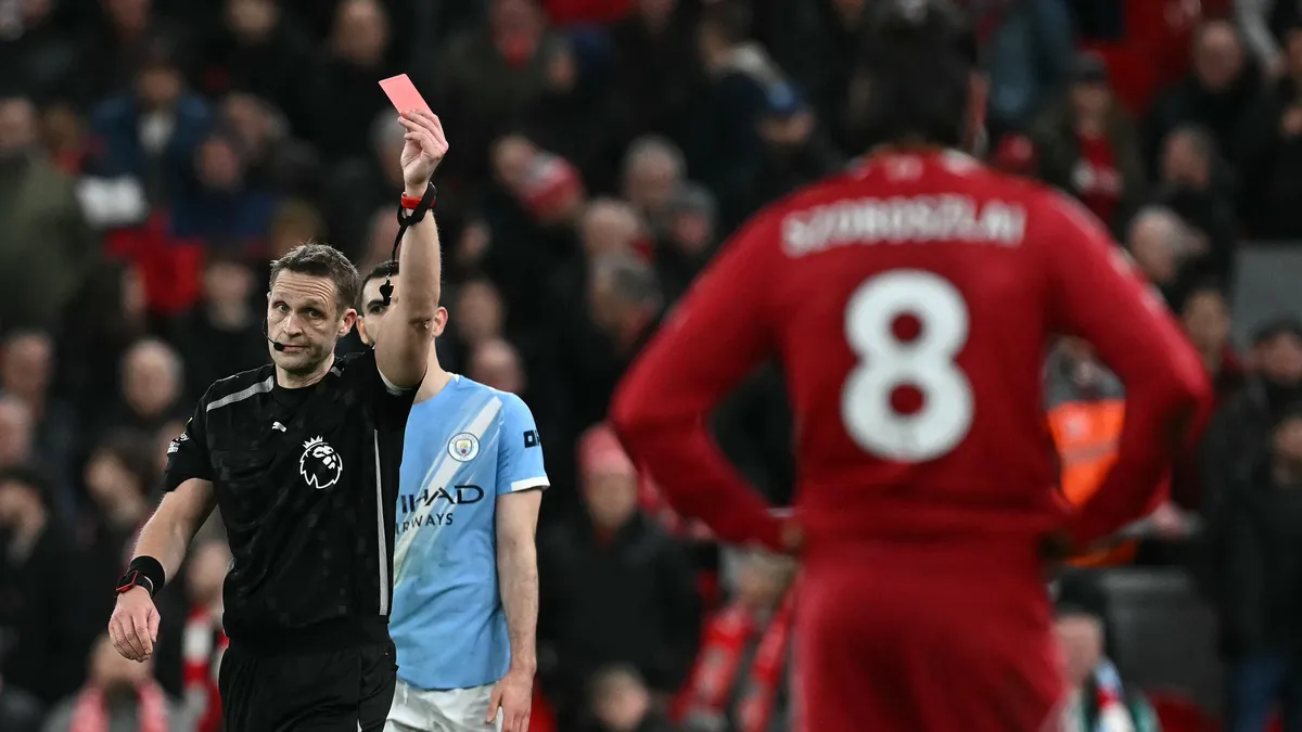 Referee Pepijn Lijnders (L) gives a red card to Liverpool's Hungarian midfielder #08 Dominik Szoboszlai (R) at the end of the English Premier League football match between Liverpool and Manchester City at Anfield in Liverpool, north west England on February 8, 2026. (Photo by Paul ELLIS / AFP) / RESTRICTED TO EDITORIAL USE. No use with unauthorized audio, video, data, fixture lists, club/league logos or 'live' services. Online in-match use limited to 120 images. An additional 40 images may be used in extra time. No video emulation. Social media in-match use limited to 120 images. An additional 40 images may be used in extra time. No use in betting publications, games or single club/league/player publications. / 