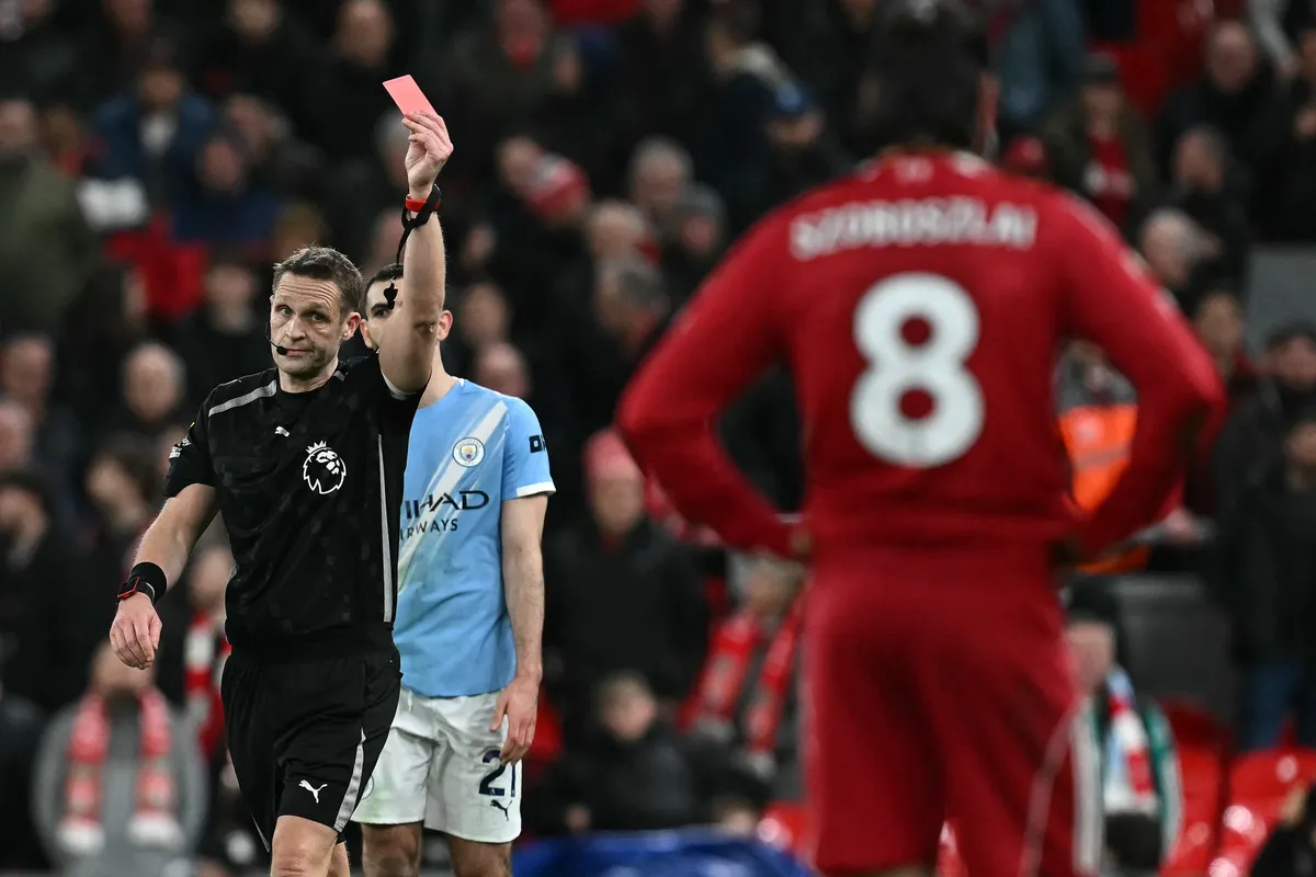 Referee Pepijn Lijnders (L) gives a red card to Liverpool's Hungarian midfielder #08 Dominik Szoboszlai (R) at the end of the English Premier League football match between Liverpool and Manchester City at Anfield in Liverpool, north west England on February 8, 2026. (Photo by Paul ELLIS / AFP) / RESTRICTED TO EDITORIAL USE. No use with unauthorized audio, video, data, fixture lists, club/league logos or 'live' services. Online in-match use limited to 120 images. An additional 40 images may be used in extra time. No video emulation. Social media in-match use limited to 120 images. An additional 40 images may be used in extra time. No use in betting publications, games or single club/league/player publications. / 