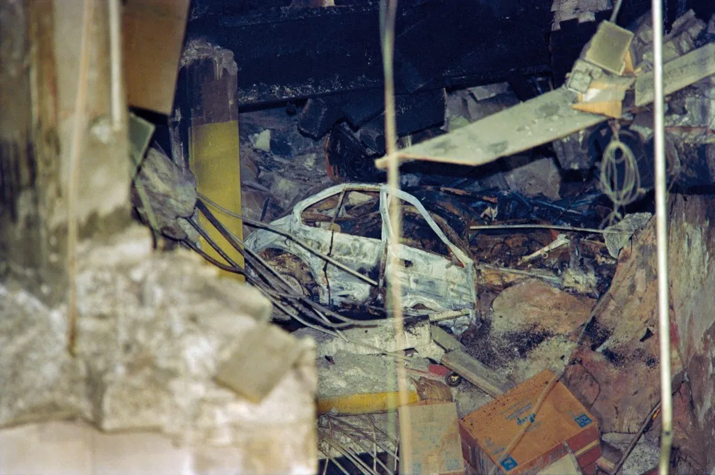 Világkereskedelmi Központ robbantása - A crushed car stands out on February 27, 1993 among the rubble within the crater from the February 26 explosion in an underground parking garage at the World Trade Center which killed six people and injuring scores more. The car bomb attack was planned by a group of islamists terrorists including Ramzi Yousef and Sheik Omar Abdel-Rahman who was sentenced to life imprisonment in October 1995 for masterminding the bombing. (Photo by MARIA BASTONE / AFP)