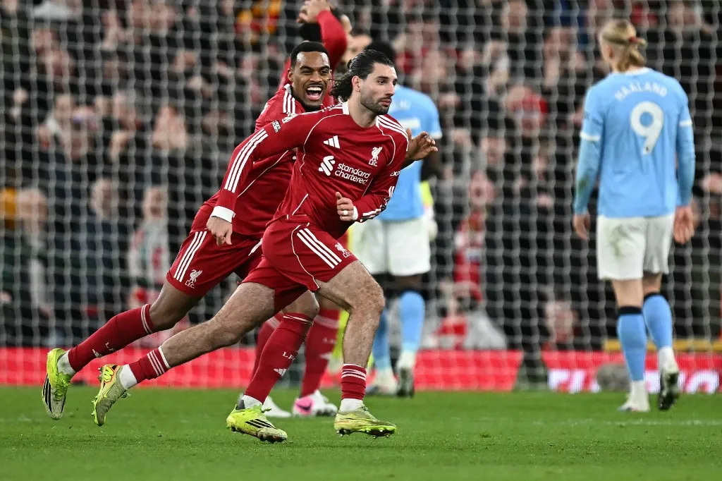 Liverpool's Hungarian midfielder #08 Dominik Szoboszlai (C) celebrates after scoring his team's first goal during the English Premier League football match between Liverpool and Manchester City at Anfield in Liverpool, north west England on February 8, 2026. (Photo by Paul ELLIS / AFP) / RESTRICTED TO EDITORIAL USE. No use with unauthorized audio, video, data, fixture lists, club/league logos or 'live' services. Online in-match use limited to 120 images. An additional 40 images may be used in extra time. No video emulation. Social media in-match use limited to 120 images. An additional 40 images may be used in extra time. No use in betting publications, games or single club/league/player publications. /