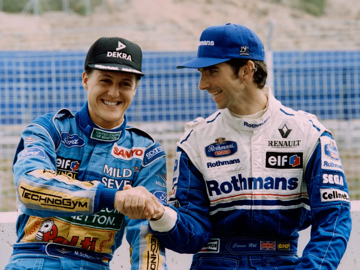 German driver Michael Schumacher (L) shakes hands with British driver Damon Hill after the final qualifying session of the Spain Formula One Grand Prix on October 15, 1994 at Jerez circuit. (Photo by Patrick KOVARIK / AFP)