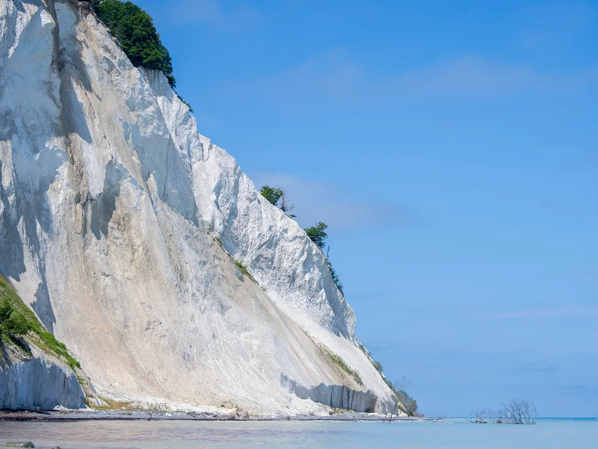 The white Chalk Cliffs of Mons Klint are pictured on July 18, 2025 on Mon Island, near  Vordingborg in southeastern Denmark. On July 13, 2025, the Chalk Cliffs of Mons Klint were designated a UNESCO World Heritage Site. Located on the eastern coast of the Danish island of Mon, the 6-kilometer-long limestone cliffs rise up to 128 meters. Formed around 70 million years ago during the Upper Cretaceous, the chalk consists mainly of microscopic algae remains (coccoliths) from an ancient sea. (Photo by Ida Marie Odgaard / Ritzau Scanpix / AFP) / Denmark OUT