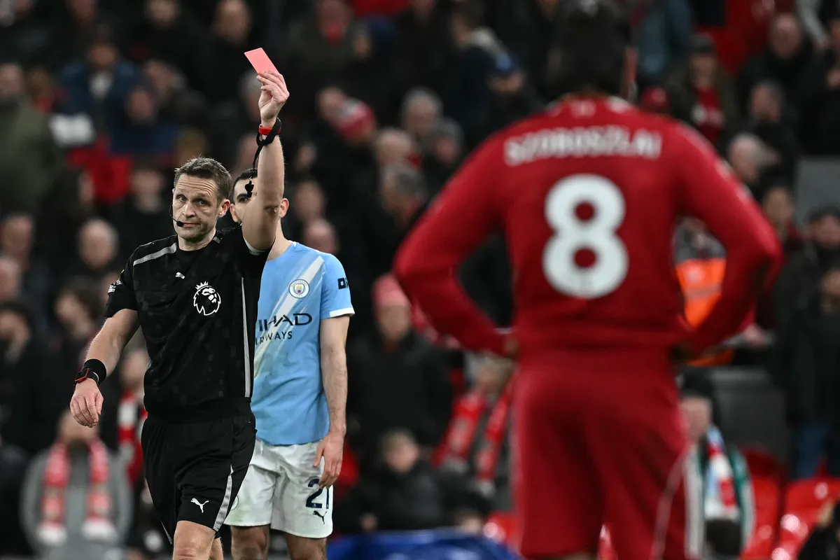 Referee Pepijn Lijnders (L) gives a red card to Liverpool's Hungarian midfielder #08 Dominik Szoboszlai (R) at the end of the English Premier League football match between Liverpool and Manchester City at Anfield in Liverpool, north west England on February 8, 2026. (Photo by Paul ELLIS / AFP) / RESTRICTED TO EDITORIAL USE. No use with unauthorized audio, video, data, fixture lists, club/league logos or 'live' services. Online in-match use limited to 120 images. An additional 40 images may be used in extra time. No video emulation. Social media in-match use limited to 120 images. An additional 40 images may be used in extra time. No use in betting publications, games or single club/league/player publications. /