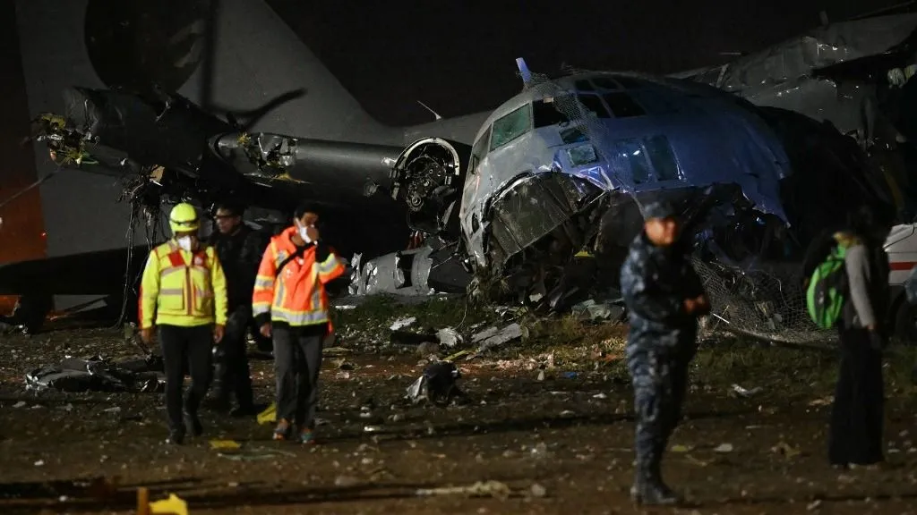 Mentőcsapatok sétálnak egy katonai repülőgép roncsai közelében, amely 2026. február 27-én zuhant le El Altóban, La Paz közelében. Fotó: AIZAR RALDES / AFP