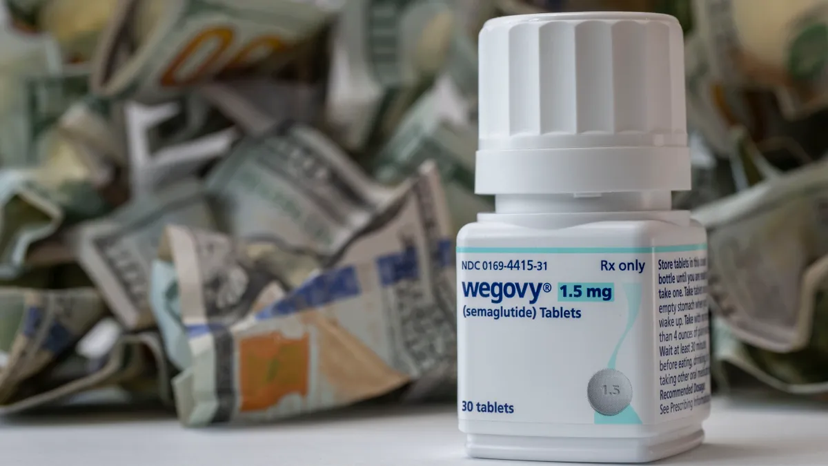 Fogyókúrás tabletta, Still life of the high cost of drugs. Closeup of a new bottle of Wegovy tablets with a pile of cash. Its a prescription medicine used with a reduced calorie diet and .and physical activity. (Photo by: Michael Siluk/UCG/Universal Images Group via Getty Images)
