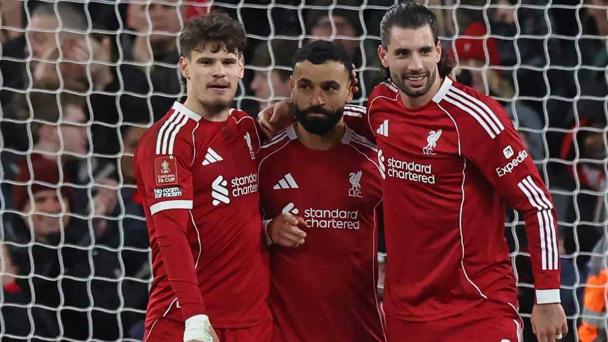 Liverpool's Egyptian striker #11 Mohamed Salah (C) celebrates with Liverpool's Hungarian defender #06 Milos Kerkez (L) and Liverpool's Hungarian midfielder #08 Dominik Szoboszlai (R) after scoring their third goal from the penalty spot during the English FA Cup fourth round football match between Liverpool and Brighton and Hove Albion at Anfield in Liverpool, north west England on February 14, 2026. (Photo by Darren Staples / AFP) / RESTRICTED TO EDITORIAL USE. No use with unauthorized audio, video, data, fixture lists, club/league logos or 'live' services. Online in-match use limited to 120 images. An additional 40 images may be used in extra time. No video emulation. Social media in-match use limited to 120 images. An additional 40 images may be used in extra time. No use in betting publications, games or single club/league/player publications. /
