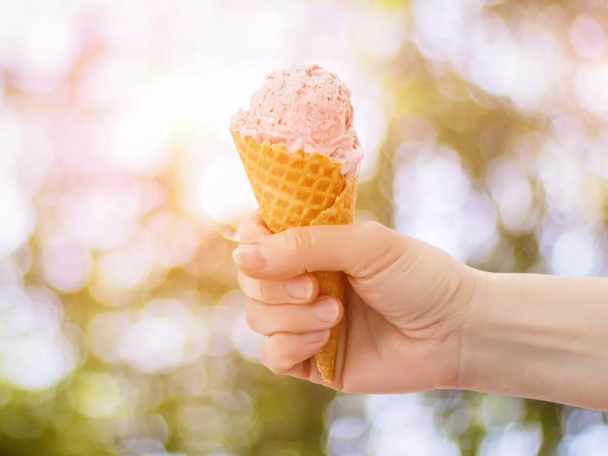 Hand with ice cream in hand on a blurred background., Nébih