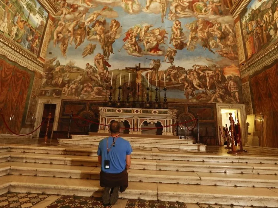 VATICAN, VATICAN CITY, MAY 03: A tourist kneels in front of the altar surmounted by Michelangelo's Last Judgment fresco, in the Sistine Chapel, ahead of the re-opening of the Vatican Museums, at the Vatican City, on May 03, 2021. The re-opening follows the third closure of the Museums since the start of the COVID-19 pandemic, with more stringent rules, including obligatory bookings, punctuality in turning up, protective masks, and social distancing. Riccardo De Luca / Anadolu Agency (Photo by RICCARDO DE LUCA / ANADOLU AGENCY / Anadolu via AFP)