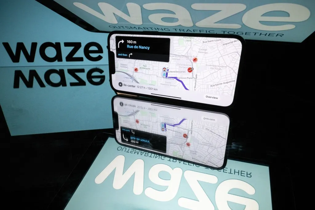 This photograph shows screens displaying the logo and the application Waze, a free navigation application in Toulouse, southern France, on January 15, 2025. (Photo by Lionel BONAVENTURE / AFP)