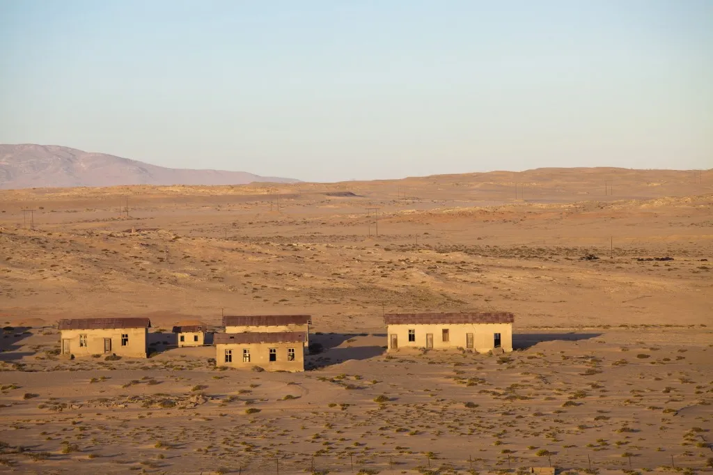 Buildings in the abandoned former German diamond mining town of Kolmanskop on the edge of the Namib Desert, Forbidden Diamond Area near Luderitz, Namibia (Photo by Lee Frost / Robert Harding Premium / robertharding via AFP)