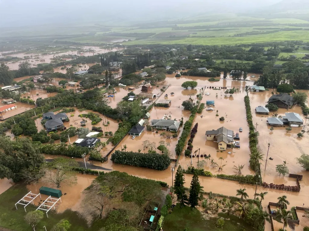 Áramszünet Hawaiin: több mint kétezren maradtak áram nélkül a pusztító áradások után - This handout photo released by the US Coast Guard, via DVIDS on March 21, 2026, shows a flooded neighborhood in Waialua on the north shore of Oahu, Hawaii, during a crew flyover with a MH-65 Dolphin helicopter assigned to Coast Guard Air Station Barbers Point in Kapolei, on March 20, 2026. Officials in Hawaii on March 20 ordered some 4,000 people living near an aging dam on the island of Oahu to evacuate the area immediately, following severe rains that have battered the region. The century-old Wahiawa dam, located in the north of Hawaii's third largest island, which is home to the state capital Honolulu, "is at imminent risk of failure," the local emergency management agency warned. (Photo by HANDOUT / US Coast Guard / AFP) / RESTRICTED TO EDITORIAL USE - MANDATORY CREDIT "AFP PHOTO / US COAST GUARD" - HANDOUT - NO MARKETING NO ADVERTISING CAMPAIGNS - DISTRIBUTED AS A SERVICE TO CLIENTS