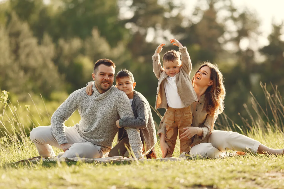 adóbevallás Family with cute little child. Father in a gray sweater. Sunset background.