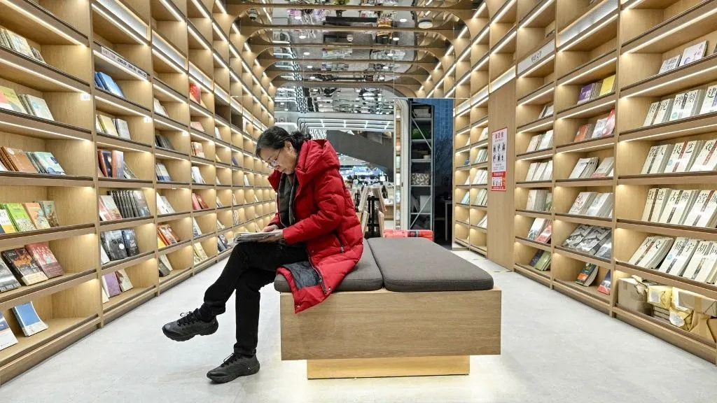 olvasás This picture taken on December 18, 2025 shows a woman reading a book at a bookstore in Beijing. Sales of hard-copy books across the country have failed to bounce back to pre-pandemic levels, data shows, despite authorities' efforts to boost domestic consumption and an e-commerce boom.
Yet in recent years the number of physical bookshops has "maintained steady growth", the head of a publishing industry group said January 2025. (Photo by Adek BERRY / AFP) / TO GO WITH China-social-books-architecture by Mary YANG