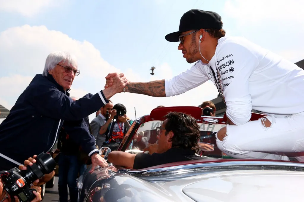 MEXICO CITY, MEXICO - NOVEMBER 01: Lewis Hamilton of Great Britain and Mercedes GP shakes hands with F1 supremo Bernie Ecclestone as he takes part in the drivers' parade before the Formula One Grand Prix of Mexico at Autodromo Hermanos Rodriguez on November 1, 2015 in Mexico City, Mexico.   Mark Thompson/Getty Images/AFP (Photo by Mark Thompson / GETTY IMAGES NORTH AMERICA / Getty Images via AFP)