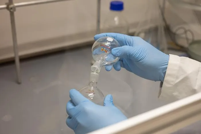 Egy kutató bemutatja az új nanorészecskék előállításához használt berendezések egy részét.