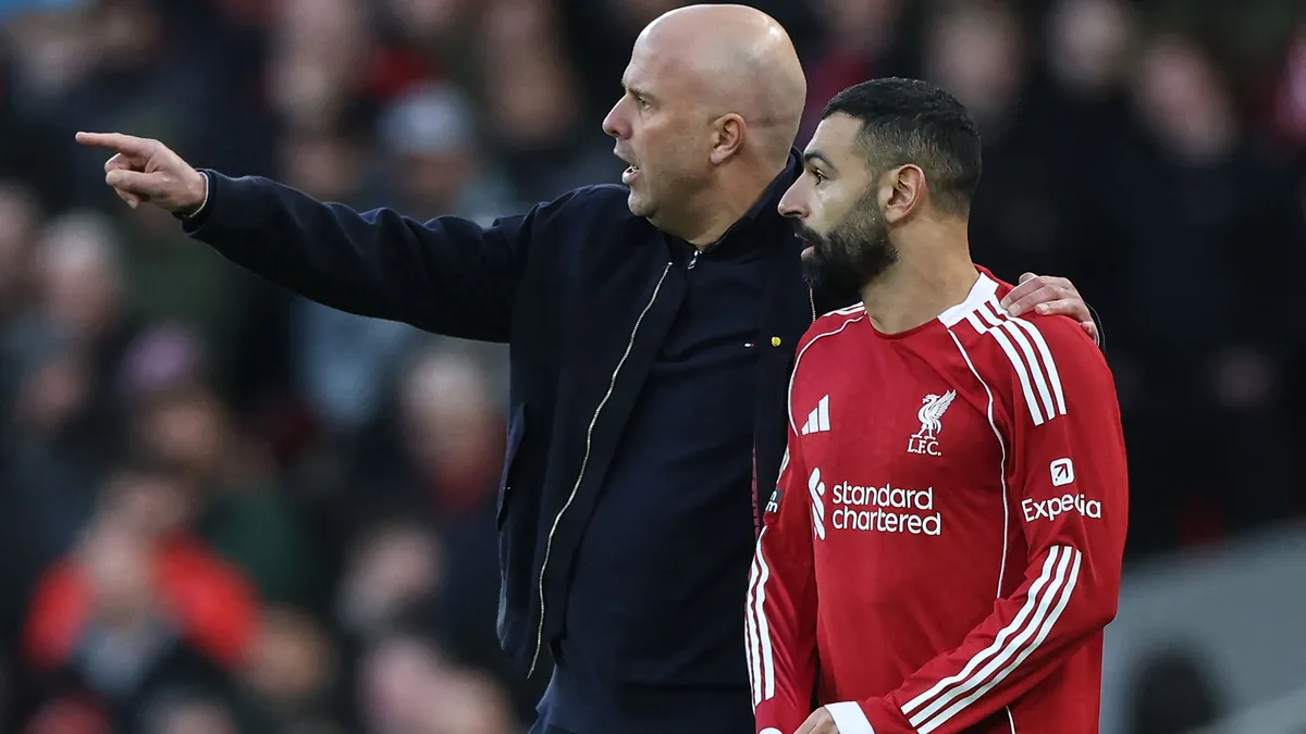 Liverpool's Dutch manager Arne Slot (L) substitutes in Liverpool's Egyptian striker #11 Mohamed Salah (R) in the second half during the English Premier League football match between Liverpool and Tottenham Hotspur at Anfield in Liverpool, north west England on March 15, 2026. (Photo by Darren Staples / AFP) / RESTRICTED TO EDITORIAL USE. No use with unauthorized audio, video, data, fixture lists, club/league logos or 'live' services. Online in-match use limited to 120 images. An additional 40 images may be used in extra time. No video emulation. Social media in-match use limited to 120 images. An additional 40 images may be used in extra time. No use in betting publications, games or single club/league/player publications. / 