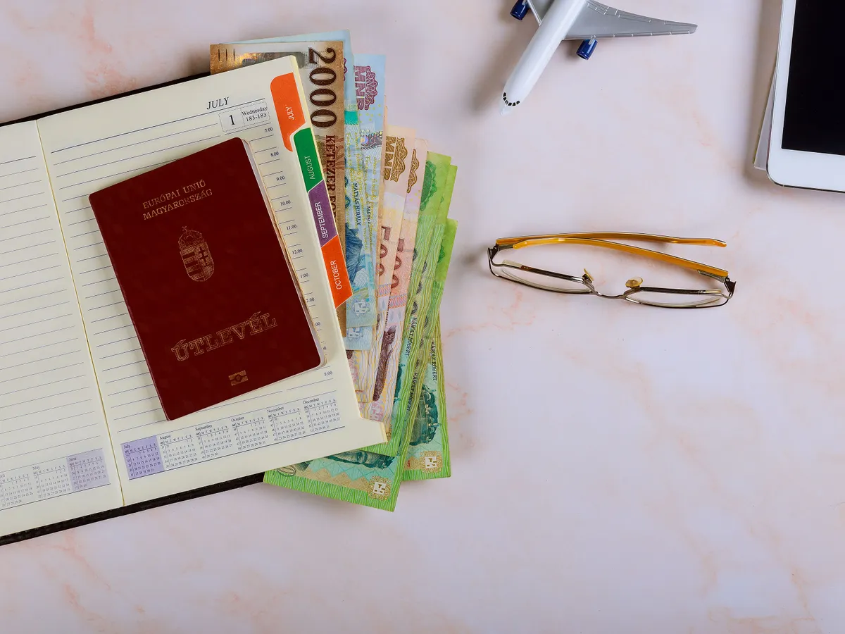 Planning travel trip open blank notebook, Magyar passport and Hungarian forint mixed banknotes on the desk