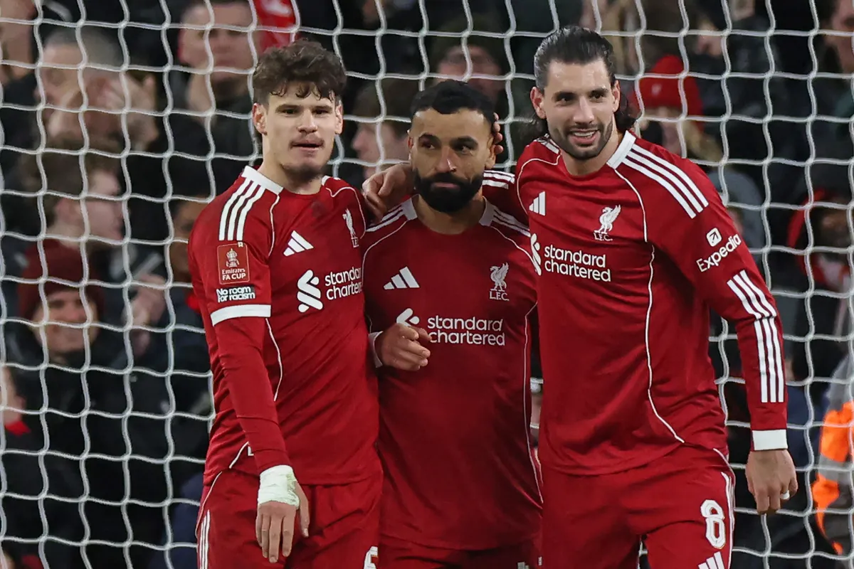 Liverpool's Egyptian striker #11 Mohamed Salah (C) celebrates with Liverpool's Hungarian defender #06 Milos Kerkez (L) and Liverpool's Hungarian midfielder #08 Dominik Szoboszlai (R) after scoring their third goal from the penalty spot during the English FA Cup fourth round football match between Liverpool and Brighton and Hove Albion at Anfield in Liverpool, north west England on February 14, 2026. (Photo by Darren Staples / AFP) / RESTRICTED TO EDITORIAL USE. No use with unauthorized audio, video, data, fixture lists, club/league logos or 'live' services. Online in-match use limited to 120 images. An additional 40 images may be used in extra time. No video emulation. Social media in-match use limited to 120 images. An additional 40 images may be used in extra time. No use in betting publications, games or single club/league/player publications. /