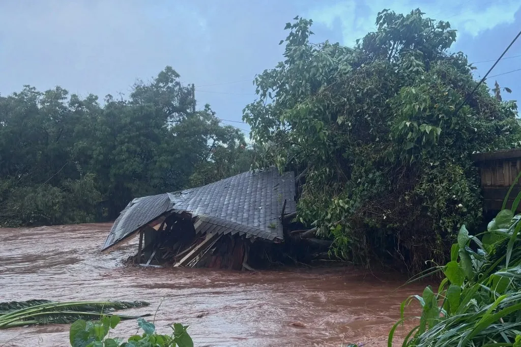 This handout photo released by the Honolulu Fire Department via Facebook on March 20, 2026 shows the remains of a house against a bridge in Waialua on northern Oahu. Officials in Hawaii on March 20 ordered some 4,000 people living near an aging dam on the island of Oahu to evacuate the area immediately, following severe rains that have battered the region. The century-old Wahiawa dam, located in the north of Hawaii's third largest island, which is home to the state capital Honolulu, "is at imminent risk of failure," the local emergency management agency warned. (Photo by HONOLULU FIRE DEPARTMENT / AFP) / RESTRICTED TO EDITORIAL USE - MANDATORY CREDIT "AFP PHOTO /  HONOLULU FIRE DEPARTMENT " - HANDOUT - NO MARKETING NO ADVERTISING CAMPAIGNS - DISTRIBUTED AS A SERVICE TO CLIENTS