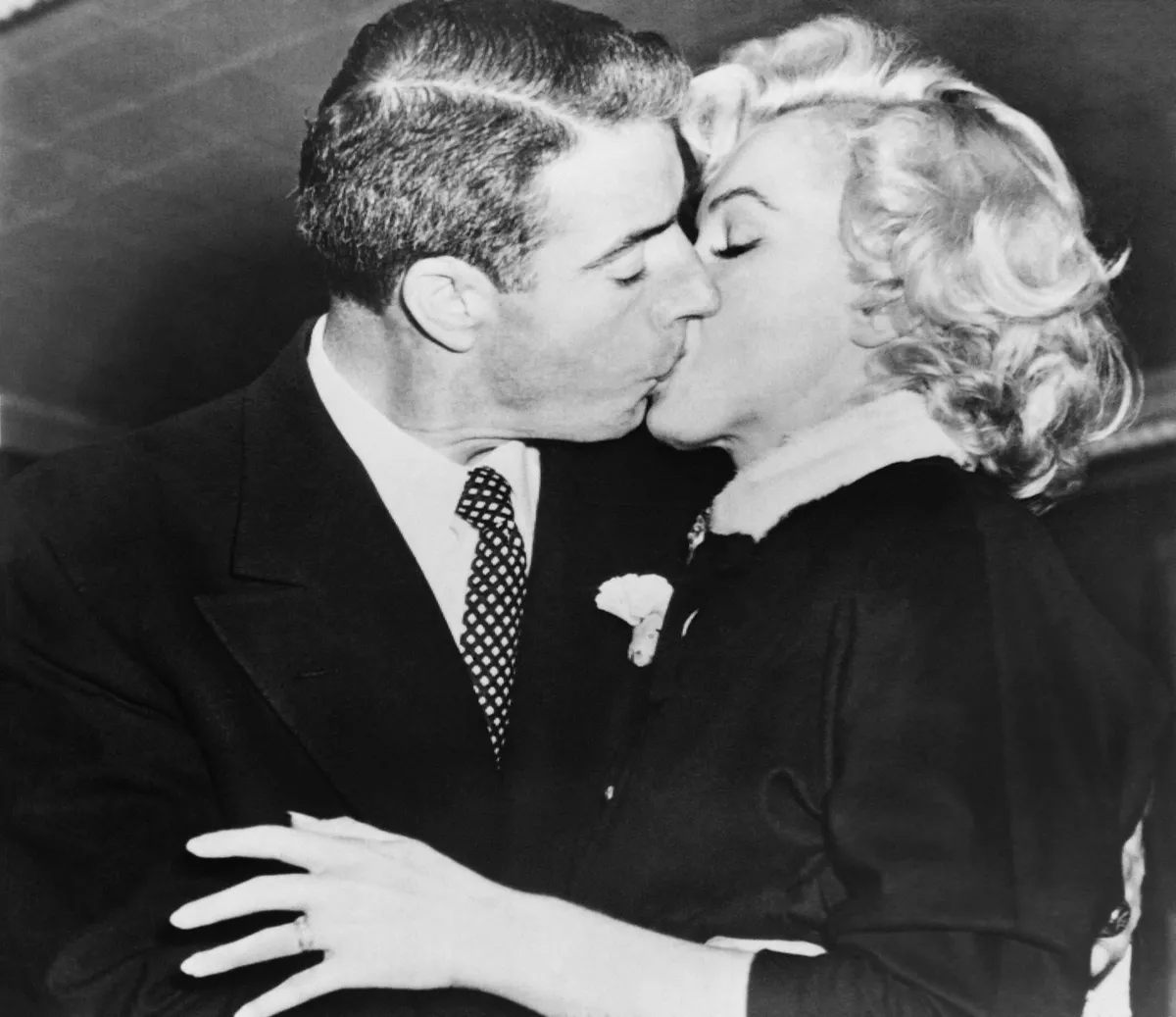 American actress Marilyn Monroe kisses her husband, former baseball player Joe Di Maggio, on January 14, 1954. (Photo by AFP)
