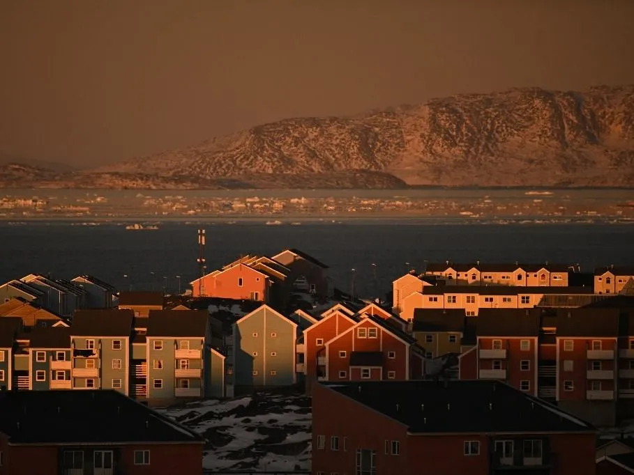 holttest, Melegrekord Grönland - (FILES) Houses of a residential area and ice floes floating on the sea are seen at the coastline of Nuuk, Greenland, on January 29, 2026. Greenland's capital Nuuk registered its warmest ever January -- beating a record that stood for 109 years -- as temperatures soared across the Arctic island's west coast, the Danish Meteorological Institute said on february 16, 2026. (Photo by Ina FASSBENDER / AFP)