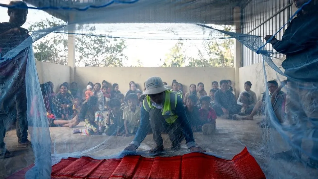 malária This photo taken on January 16, 2025 shows volunteer Nhoun Niyok (C) showing villagers how to use a mosquito net to prevent malaria at Pu Kesh village, Keo Seima district in Cambodia's northeastern Mondulkiri province. Cambodia is stepping up a "last mile" push to wipe out the mosquito-borne disease, focusing on hard-to-reach pockets of population in remote, forested or mountainous areas. (Photo by TANG CHHIN Sothy / AFP) / To go with 'CAMBODIA-HEALTH-MALARIA,FOCUS' by Suy SE