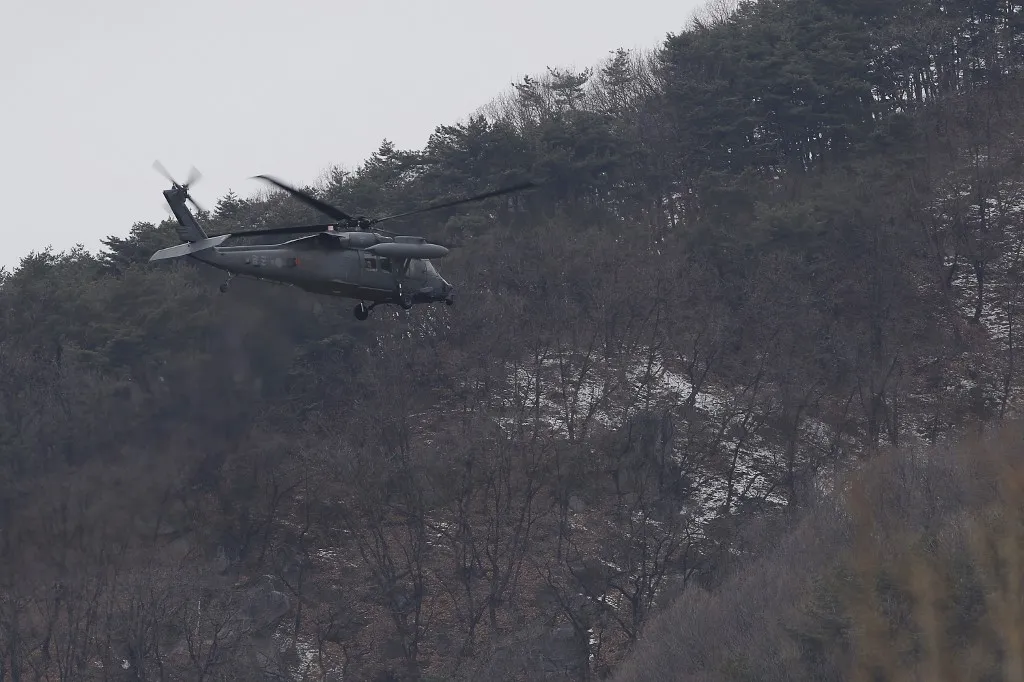 A helikopter-baleset után mentőcsapatok kutatnak - Képünk illusztráció Fotó: SEUNG-IL RYU / NurPhoto On February 26, 2026, in Yeongju, South Korea, a South Korean Air Force helicopter conducts a low flight to search for the F-16C flight recorder near Yongamsan mountain in Yeongju, South Korea. An F-16C fighter jet crashes near Yeongju in North Gyeongsang Province on Wednesday, but the pilot safely ejects, the Air Force says. The aircraft, assigned to Chungju Air Base, goes down in a mountainous area near Yeongju at about 7:31 p.m. during a nighttime training exercise, according to the Air Force. (Photo by Seung-il Ryu/NurPhoto) (Photo by Seung-il Ryu / NurPhoto via AFP)