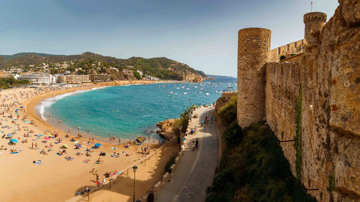 Tossa de Mar, TossadeMar,

TOSSA DE MAR, SPAIN - SEPTEMBER 05 2023: View of the main beach of Tossa de Mar and the fortress wall. Badia de Tossa bay. Wide sandy beach on the shore of the turquoise sea