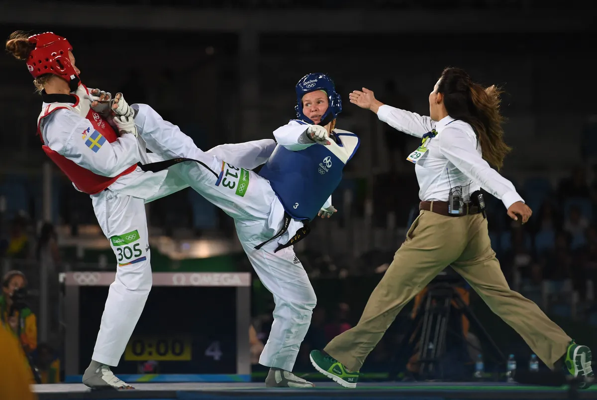 Sweden's Nikita Glasnovic (C) competes against Finland's Suvi Mikkonen (L) during their womens taekwondo quarter-final bout in the -57kg category as part of the Rio 2016 Olympic Games, on August 18, 2016, at the Carioca Arena 3, in Rio de Janeiro. (Photo by Kirill KUDRYAVTSEV / AFP)