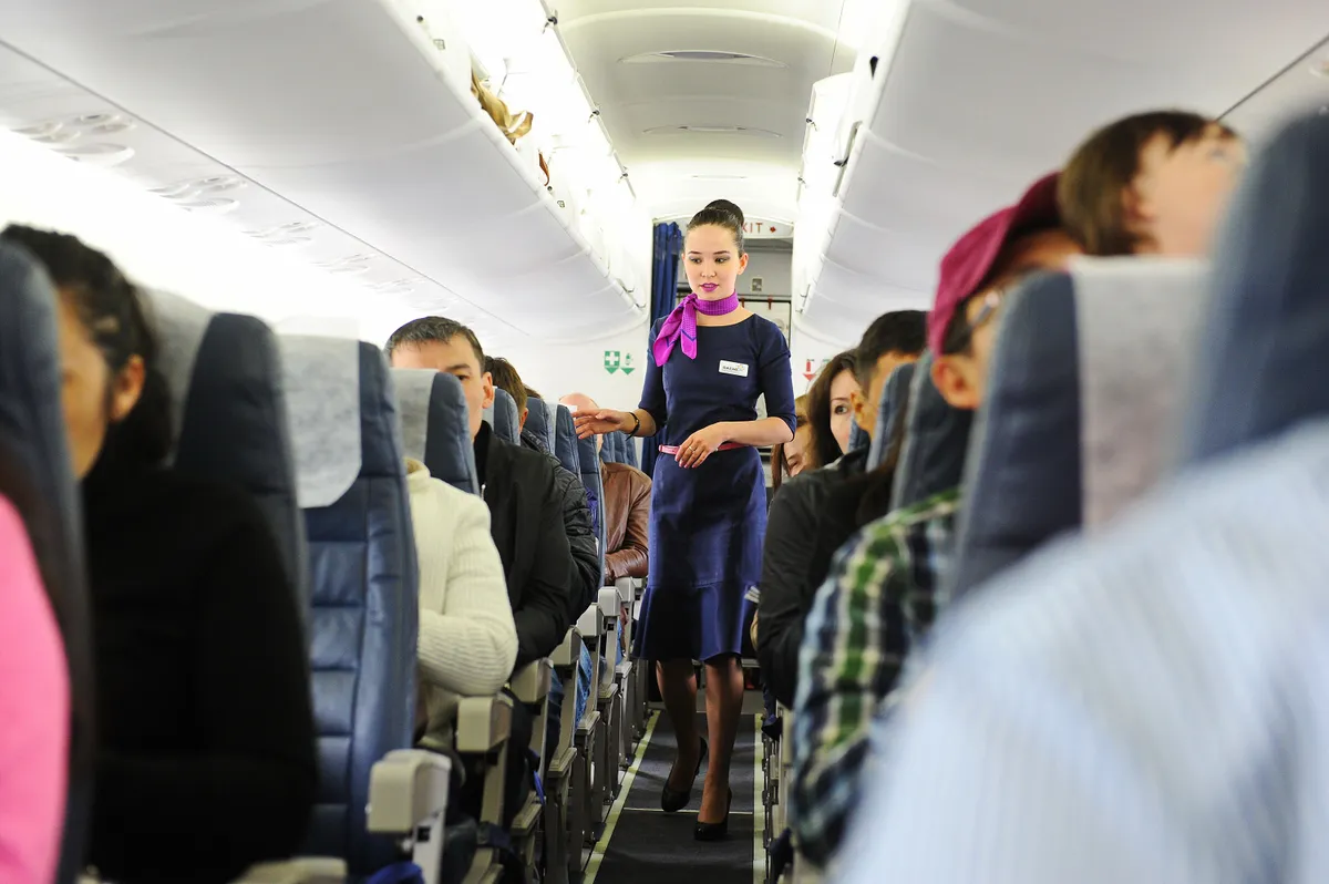 Almaty, Kazakhstan - 05.06.2016 : A flight attendant checks passengers after boarding.