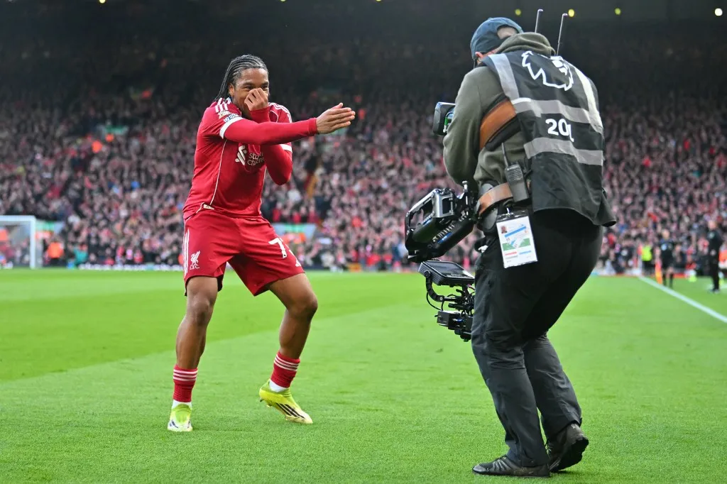 Liverpool's English striker #73 Rio Ngumoha celebrates for the TV camera after scoring the opening goal of the English Premier League football match between Liverpool and Fulham at Anfield in Liverpool, north west England on April 11, 2026. (Photo by ANDY BUCHANAN / AFP) / RESTRICTED TO EDITORIAL USE. No use with unauthorized audio, video, data, fixture lists, club/league logos or 'live' services. Online in-match use limited to 120 images. An additional 40 images may be used in extra time. No video emulation. Social media in-match use limited to 120 images. An additional 40 images may be used in extra time. No use in betting publications, games or single club/league/player publications. / 