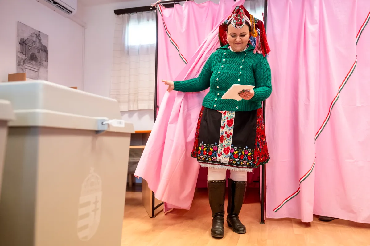 Rimóc, 2026. április 12.
A Rimóci Folklór Manufaktúra és Faluszépítő Egyesület helyi palóc népviseletbe öltözött tagja kilép a szavazófülkéből az országgyűlési választáson a rimóci polgármesteri hivatalban kialakított szavazókörben 2026. április 12-én.
MTI/Komka Péter