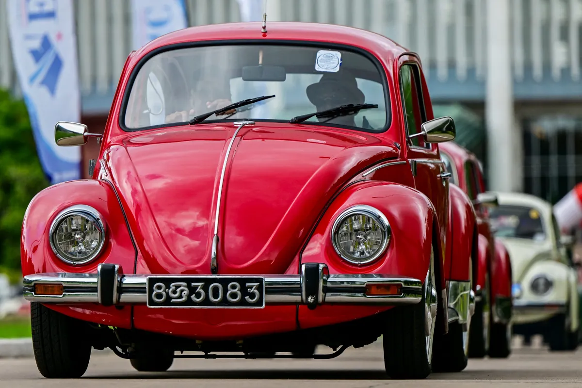 Owners of vintage Volkswagen Beetle cars take part in celebrations to mark World Volkswagen Day in Colombo on June 22, 2025. (Photo by Ishara S. KODIKARA / AFP)