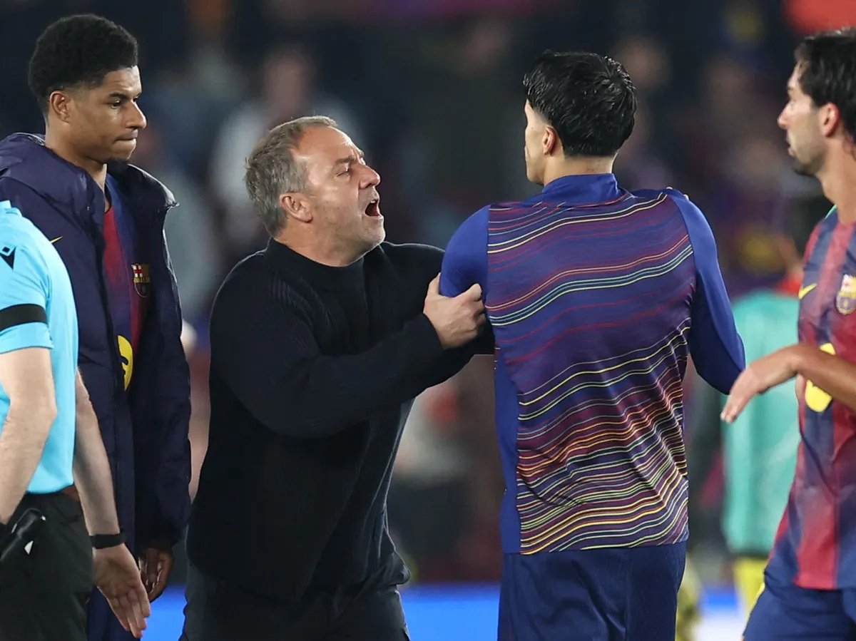 Barcelona's German coach Hans-Dieter Flick prevents Barcelona's Portuguese defender #02 Joao Cancelo from discussing with referee at the end of the UEFA Champions League quarter final first leg football match between FC Barcelona and Club Atletico de Madrid at Camp Nou Stadium in Barcelona on April 8, 2026. Atletico Madrid won 0-2. (Photo by Josep LAGO / AFP)
