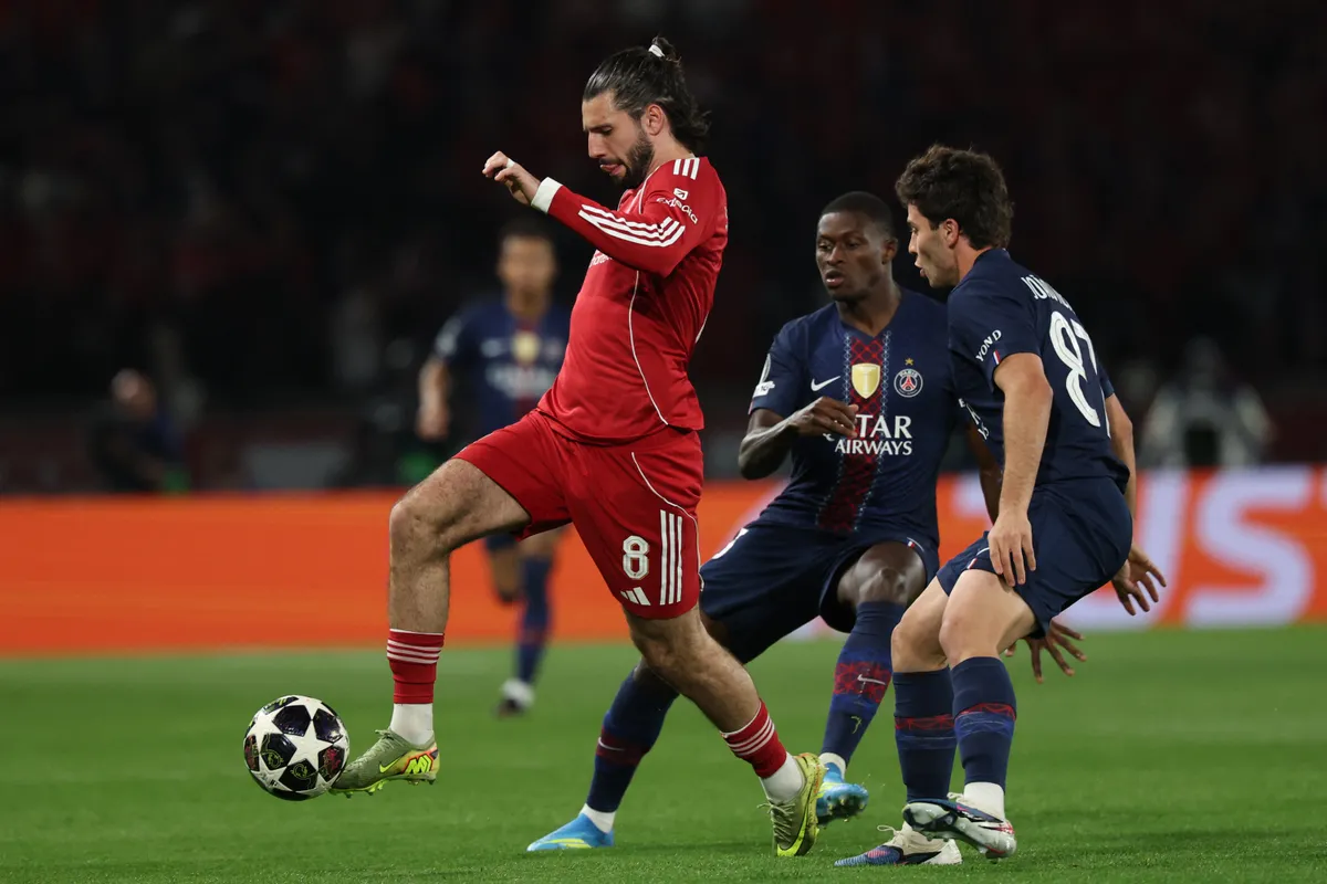 Liverpool's Hungarian midfielder #08 Dominik Szoboszlai (L) fights for the ball with Paris Saint-Germain's Portuguese defender #25 Nuno Mendes and Paris Saint-Germain's Portuguese midfielder #87 Joao Neves during the UEFA Champions League quarter-final first leg football match between Paris Saint-Germain (PSG) and Liverpool FC at the Parc des Princes stadium in Paris on April 8, 2026. (Photo by Anne-Christine POUJOULAT / AFP)