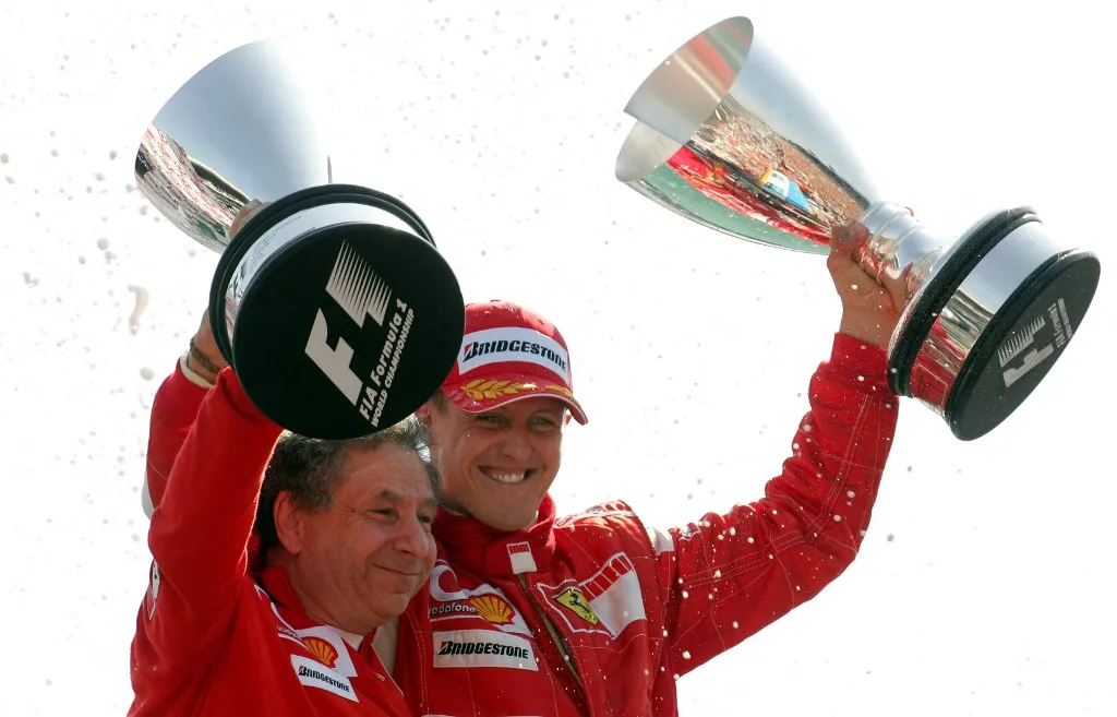 German Formula One driver Michael Schumacher (R) and French team principal Jean Todt (L) of Scuderia Ferrari team celebrate after Schumacher won the Grand Prix of Italy at the race track in Monza, Italy, Sunday, 10 September 2006. Photo: Gero Breloer (Photo by GERO BRELOER / dpa Picture-Alliance via AFP)