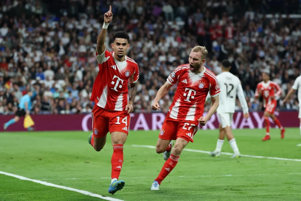 Bayern Munich's Colombian forward #14 Luis Diaz celebrates scoring the opening goal with Bayern Munich's Austrian midfielder #27 Konrad Laimer (R) during the UEFA Champions League quarter final first leg football match between Real Madrid CF and FC Bayern Munich at Santiago Bernabeu Stadium in Madrid on April 7, 2026. (Photo by Thomas COEX / AFP)