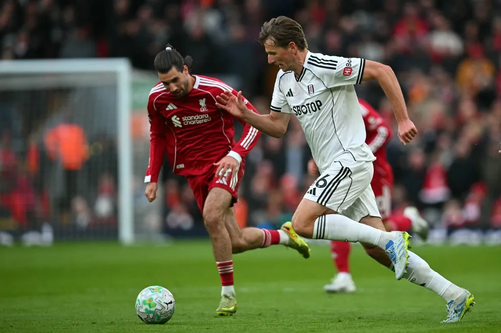 Fulham's Norweigan midfielder #16 Sander Berge (R) vies with Liverpool's Hungarian midfielder #08 Dominik Szoboszlai (L) during the English Premier League football match between Liverpool and Fulham at Anfield in Liverpool, north west England on April 11, 2026. (Photo by ANDY BUCHANAN / AFP) / RESTRICTED TO EDITORIAL USE. No use with unauthorized audio, video, data, fixture lists, club/league logos or 'live' services. Online in-match use limited to 120 images. An additional 40 images may be used in extra time. No video emulation. Social media in-match use limited to 120 images. An additional 40 images may be used in extra time. No use in betting publications, games or single club/league/player publications. / 