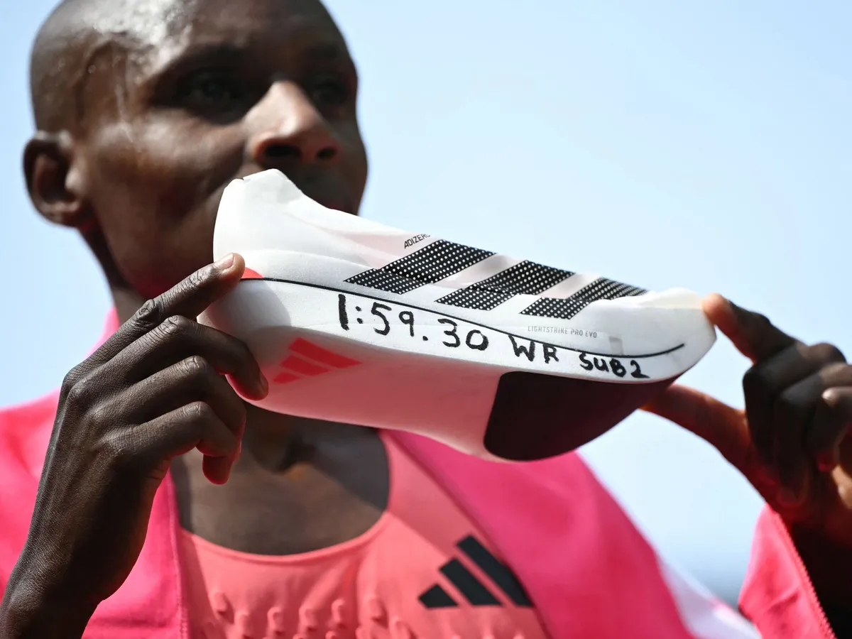 Sabastian Sawe, SabastianSawe,
maratonfutó-rekord, maratonfutó, rekord, maratonfutás, kétóramaratonfutó-rekord, Kenya's Sabastian Sawe poses with his new world record time written on his running shoe at the finish of the 2026 London Marathon in central London on April 26, 2026. Kenya's Sabastian Sawe broke the two-hour mark for the first time in history on Sunday in winning the London Marathon. (Photo by JUSTIN TALLIS / AFP) / “Restricted to editorial use - sponsorship of content subject to LMEL agreement”.