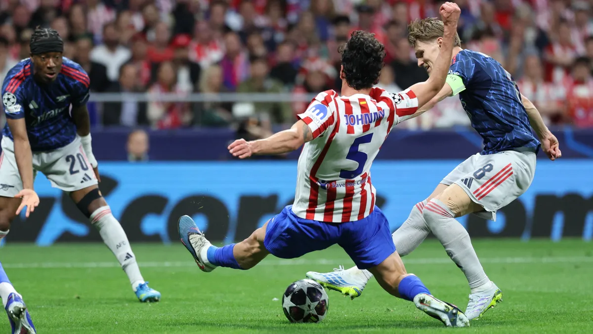 Atletico Madrid's US midfielder #05 Johnny Cardoso tackles Arsenal's Norwegian midfielder #08 Martin Odegaard during the UEFA Champions League semi-final first leg football match between Club Atletico de Madrid and Arsenal at the Metropolitano stadium in Madrid on April 29, 2026. (Photo by Thomas COEX / AFP)