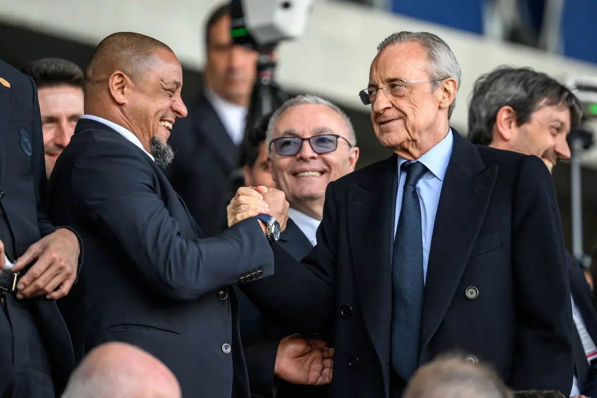 Real Madrid's president Florentino Perez (R) shakes hands with former soccer player Roberto Carlos prior to the UEFA Youth League final football match between Club Brugge and Real Madrid at Stade de la Tuiliere in Lausanne, on April 20, 2026. (Photo by Fabrice COFFRINI / AFP)