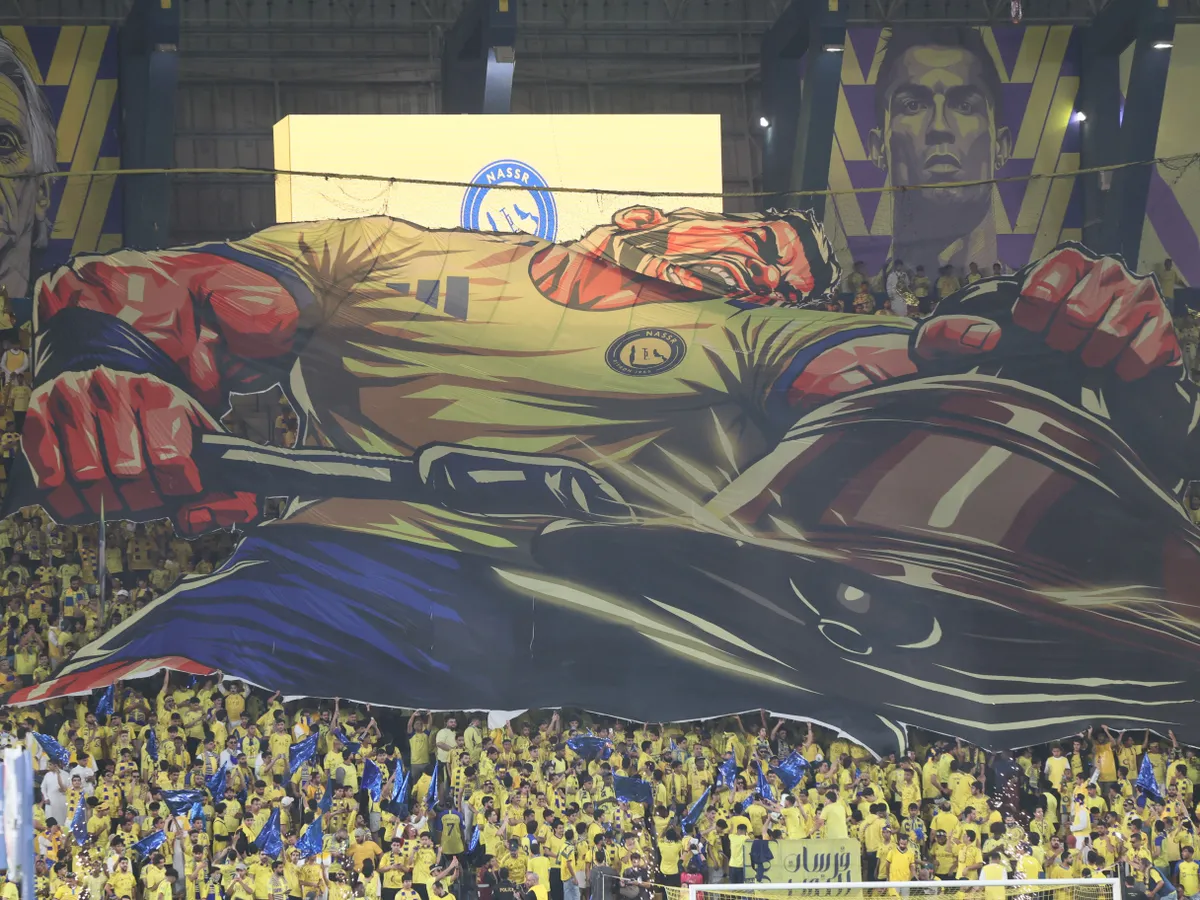 Nassr supporters display a giant poster of Portuguese forward Cristiano Ronaldo during the Saudi Pro League football match between Al-Nassr and Al-Ahli at the Al-Awwal Park Stadium in Riyadh on April 29, 2026. (Photo by Fayez Nureldine / AFP)