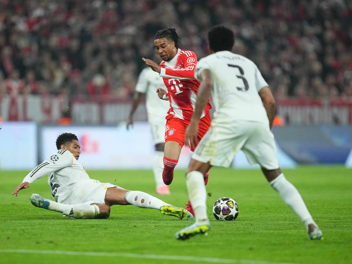 Jude Bellingham (Real Madrid) and Michael Olise (Bayern Munich) battle for the ball during UEFA Champions league Quarter Final UEFA Champions League: Bayern Munich and Real Madrid at Allianz Arena, Munich, Germany on April 15  2026. (Photo by Ulrik Pedersen/NurPhoto) (Photo by Ulrik Pedersen / NurPhoto via AFP)
