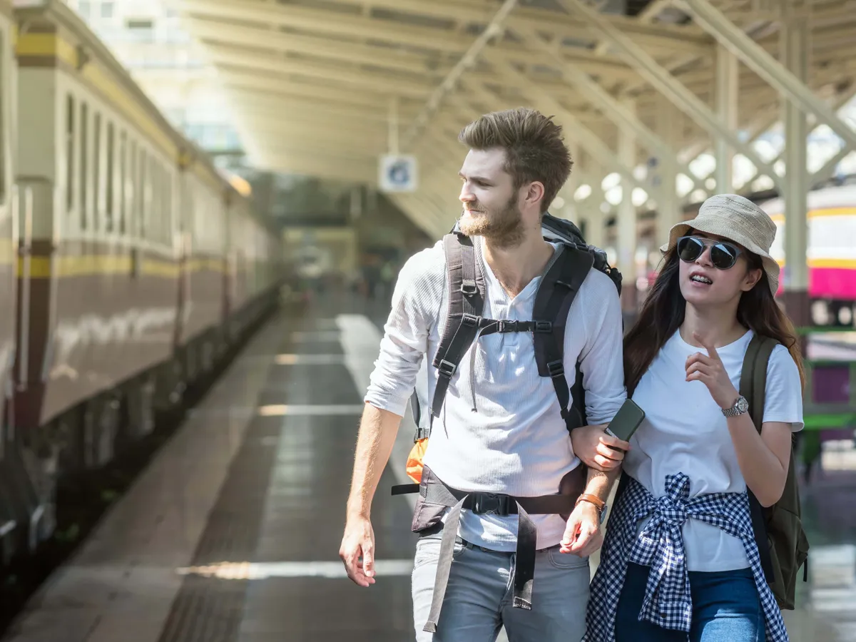 átverési trükkök, illusztráció turista pár az állomáson