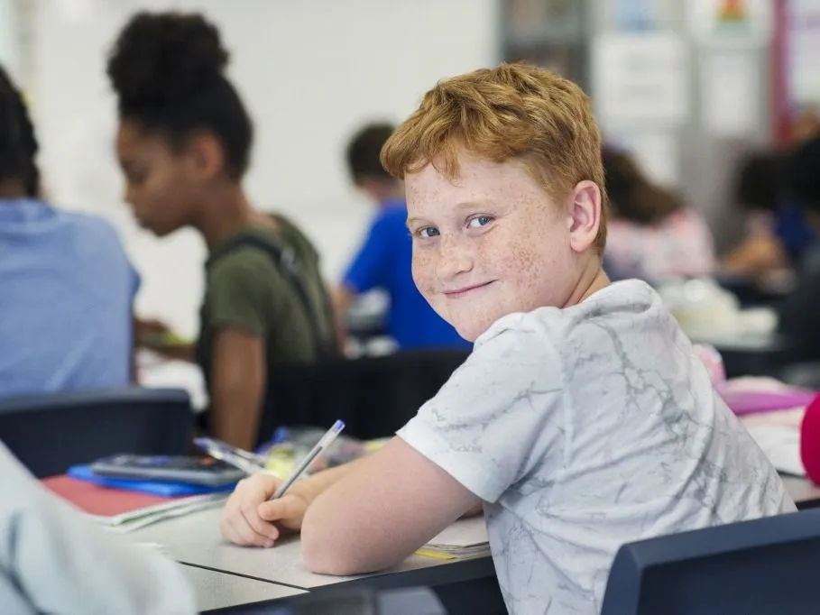 evolúció Portrait smiling, confident junior high school boy student studying at desk in classroom. (Photo by CAIA IMAGE/SCIENCE PHOTO LIBRARY / NEW / Science Photo Library via AFP)