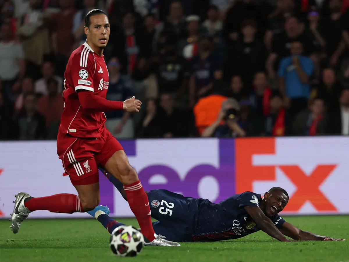 Paris Saint-Germain's Portuguese defender #25 Nuno Mendes falls next to Liverpool's Dutch defender #04 Virgil van Dijk (L) during the UEFA Champions League quarter-final first leg football match between Paris Saint-Germain (PSG) and Liverpool FC at the Parc des Princes stadium in Paris on April 8, 2026. (Photo by Anne-Christine POUJOULAT / AFP)