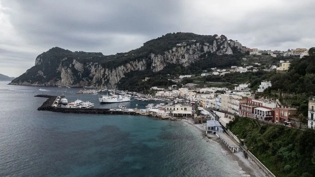 Capri, the island in the Gulf of Naples, is famous for its steep terrain, exclusive hotels, and shopping, which ranges from high fashion to limoncello to handcrafted leather sandals. One of the best-known natural sites is the Blue Grotto, a dark cavity where the sea water is tinged electric blue by the presence of an underground cave that filters sunlight. During the summer, the island's coastline, full of coves, attracts many yachts in Italy, on October 22, 2024. (Photo by Paolo Manzo/NurPhoto) (Photo by Paolo Manzo / NurPhoto via AFP)